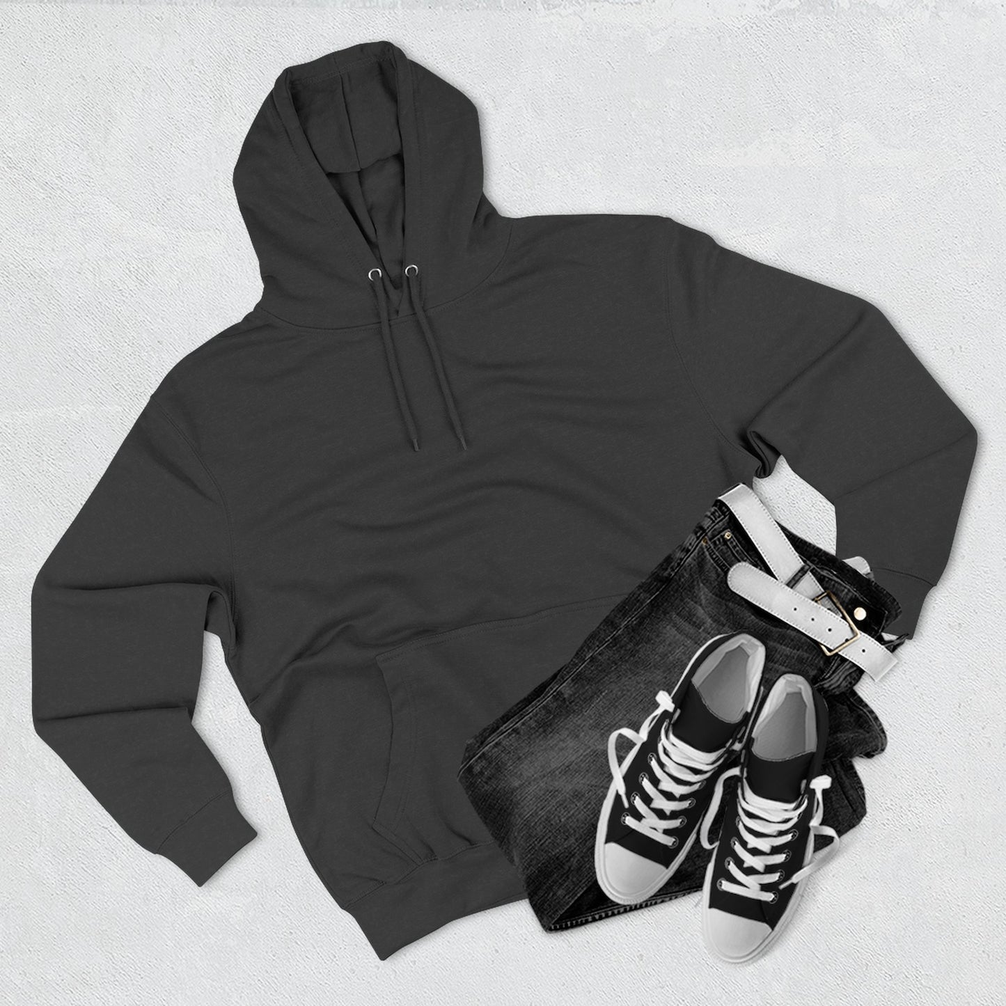 Black essentials hoodie with black jeans, white belt, and black sneakers flat lay