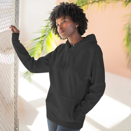 Woman wearing black essentials hoodie in sunlit modern space with palm leaves, Ghita Shop